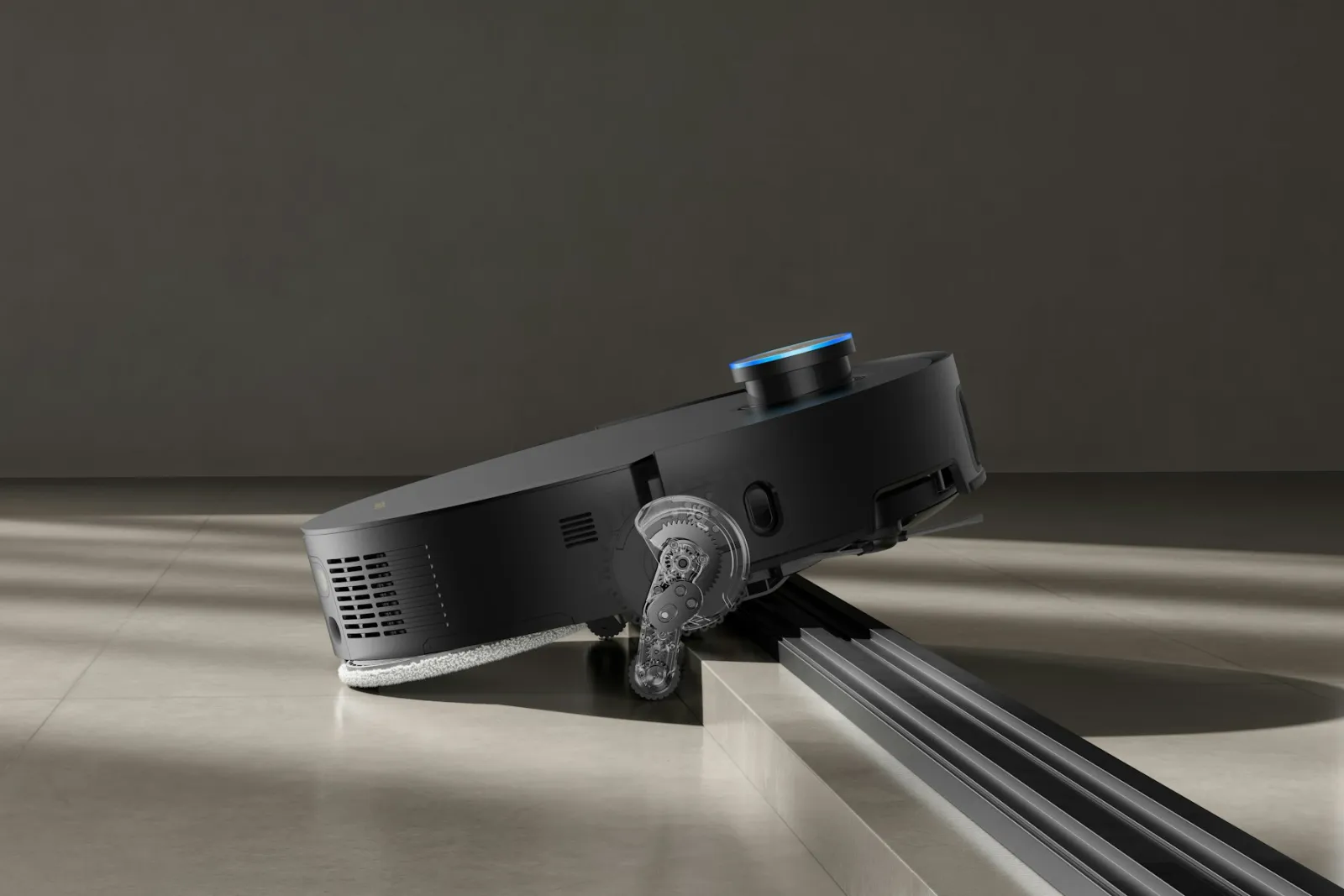 [ÖRNEK] Eşik aşarken tekerlek mekanizması görünen robot süpürge — ürün ve servis anlatımı için kullanılan stok görsel