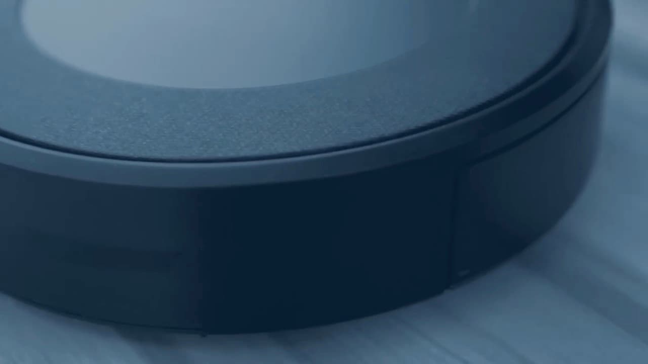 [ÖRNEK] Bir robot süpürgenin gövde kenarı, tampon şeridi ve toz haznesi kapağını gösteren yakın plan — gerçek Robot Fix atölye çekimi yerine kullanılan geçici görüntü
